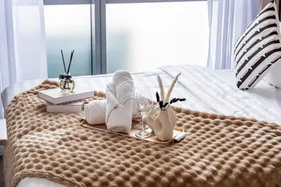 a bed with towels and glasses and books on it at #TRX KL #2BR #4Pax #2Gbps #Netflix #Hotel Feel in Kuala Lumpur