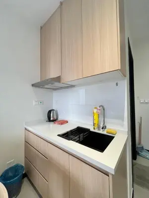 a kitchen with wooden cabinets and a stove top oven at Arte Plus Ampang By Comfortcorner in Kuala Lumpur