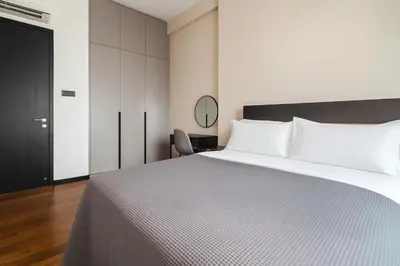 a bedroom with a large white bed and a chair at Opus by Soulasia in Kuala Lumpur