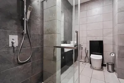 a bathroom with a shower and a toilet and a sink at Opus by Soulasia in Kuala Lumpur