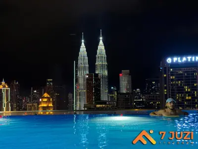 a man in a swimming pool with a city skyline at KL &118 Tower View 1R1B Netflix 19F & Best View Infinity Pool in Kuala Lumpur