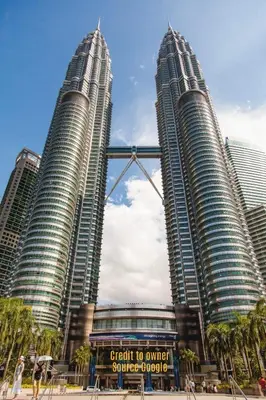 three tall buildings in a city with palm trees at View KLCC 3 Bedroom Homestay Kenwingston Platz in Kuala Lumpur