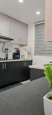 a kitchen with black and white cabinets and a counter at Puncak Sentul KL with 3 Bedroom Homestay in Kuala Lumpur