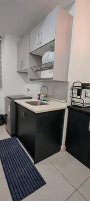 a kitchen with a sink and white cabinets and a rug at Puncak Sentul KL with 3 Bedroom Homestay in Kuala Lumpur