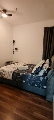 a bedroom with a bed with a blue comforter at Puncak Sentul KL with 3 Bedroom Homestay in Kuala Lumpur