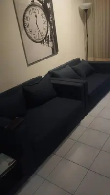 a black couch with a clock on the wall at Seri Bukit Ceylon Dreamy Destiny luxe Suites in Kuala Lumpur