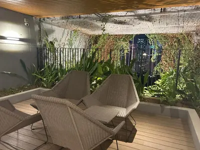 two wicker chairs sitting on a patio with an aquarium at Ceylonz Suites Bukit Bintang By ICEFLY in Kuala Lumpur