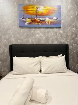 a bedroom with a bed with a painting on the wall at Ceylonz Suites Bukit Bintang By ICEFLY in Kuala Lumpur