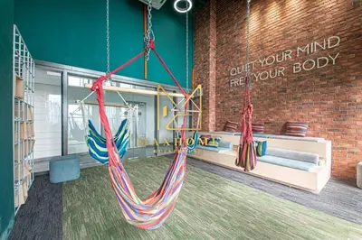 a room with two hammocks hanging from a brick wall at Maxhome Cozy at Riveria KL in Kuala Lumpur