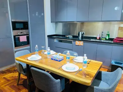 a kitchen with a wooden table with plates and water bottles at KLCC The Mews Luxury suites Malaysia in Kuala Lumpur