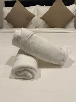 a rolled up towel on top of a bed at Cyelonz Suites in Kuala Lumpur
