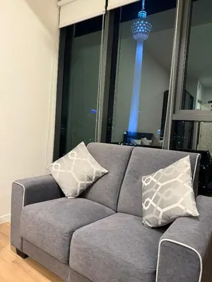 a gray couch with pillows in a living room at Cyelonz Suites in Kuala Lumpur