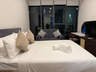 a bed with a white towel on top of it at Cyelonz Suites in Kuala Lumpur