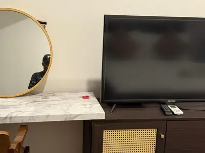 a tv sitting on top of a table with a mirror at Cyelonz Suites in Kuala Lumpur