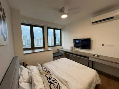 a bedroom with a bed and a desk with a television at City View Retreat in Kuala Lumpur