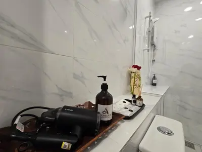 a camera and a bottle of wine on a counter in a bathroom at Seko Suites by Aurelius Chow Kit in Kuala Lumpur