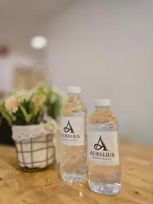 two bottles of water sitting on a wooden table at Seko Suites by Aurelius Chow Kit in Kuala Lumpur