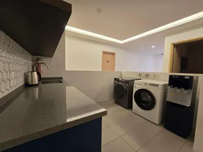 a kitchen with a washing machine and a washer at Seko Suites by Aurelius Chow Kit in Kuala Lumpur