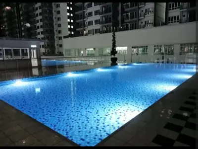 a large swimming pool with blue lights in a building at Modern High-Floor 2BR Retreat 9km to KL City Centre in Kuala Lumpur