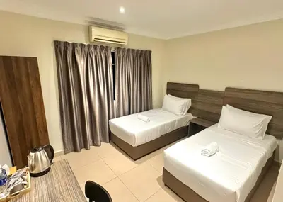 a hotel room with two beds and a table at Swing & Pillows - Bukit Bintang City Centre in Kuala Lumpur