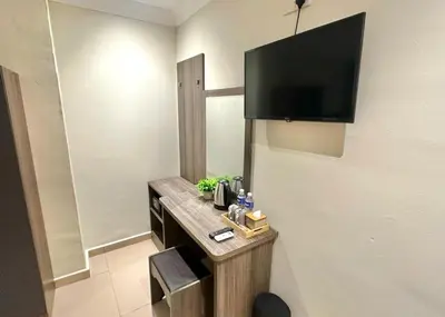 a room with a desk with a television on the wall at Swing & Pillows - Bukit Bintang City Centre in Kuala Lumpur
