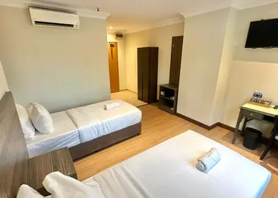 a hotel room with two beds and a television at Swing & Pillows - Bukit Bintang City Centre in Kuala Lumpur