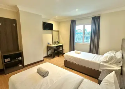 a hotel room with two beds and a desk at Swing & Pillows - Bukit Bintang City Centre in Kuala Lumpur