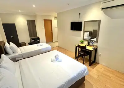 a hotel room with two beds and a desk with a mirror at Swing & Pillows - Bukit Bintang City Centre in Kuala Lumpur