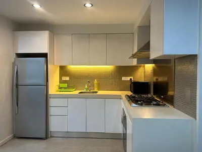 a kitchen with white cabinets and a stainless steel refrigerator at Bukit Bintang Fairlane suite by Rose in Kuala Lumpur
