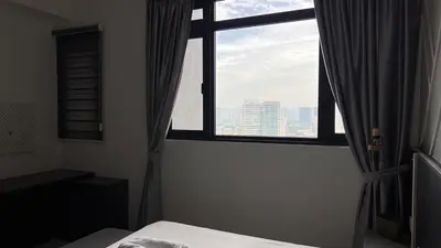 a bedroom with a window with a view of a city at Cozy Chambers Studio KLCC Grand Opening Sale in Kuala Lumpur