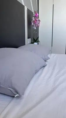 two beds with white sheets and a vase with pink flowers at Cozy Chambers Studio KLCC Grand Opening Sale in Kuala Lumpur