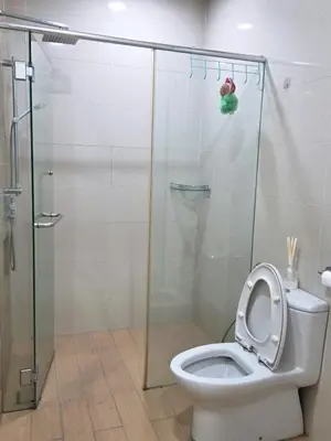 a bathroom with a toilet with a glass shower stall at Camellia Serviced Suites in Kuala Lumpur