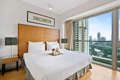 a bedroom with a large bed and a large window at My Habitat KL in Kuala Lumpur