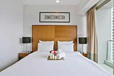a bedroom with a large white bed with flowers on it at My Habitat KL in Kuala Lumpur