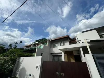 a large white house with a cloudy sky at Bukit Damansara Terrace in Kuala Lumpur