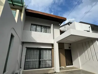 a white house with a building at Bukit Damansara Terrace in Kuala Lumpur