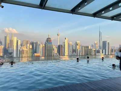 a infinity pool with a city skyline in the background at Enjoy your stay Regalia view KLCC in Kuala Lumpur