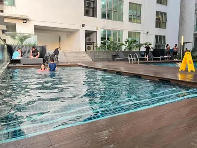 a group of people in a swimming pool at Enjoy your stay Regalia view KLCC in Kuala Lumpur