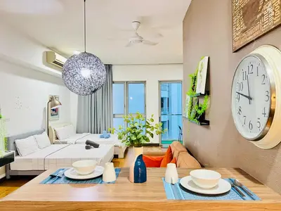 a living room with a large clock on the wall at Enjoy your stay Regalia view KLCC in Kuala Lumpur