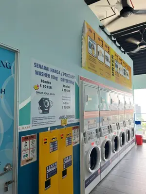 a laundry room with washing machines and signs on the wall at TheRiv Boutique Suites at Riveria City KL Sentral by Suite Dwellings in Kuala Lumpur