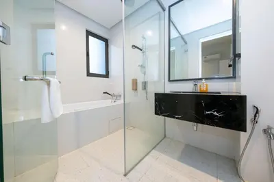 a bathroom with a glass shower and a sink at La Gente X Pavilion Embassy Serviced Suites in Kuala Lumpur
