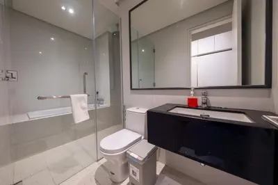 a bathroom with a toilet and a sink and a shower at La Gente X Pavilion Embassy Serviced Suites in Kuala Lumpur