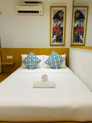 a bedroom with a white bed with blue and white pillows at Vivids Hotel Bukit Bintang in Kuala Lumpur
