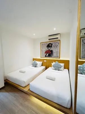 two beds in a room with white walls at Vivids Hotel Bukit Bintang in Kuala Lumpur
