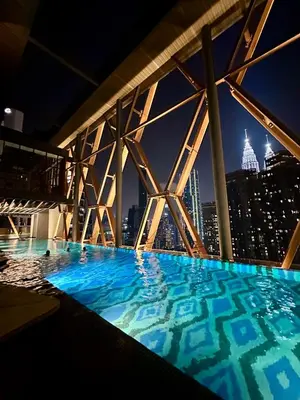 a swimming pool with a view of the city at night at SKYLINE HOME BY SCARLETZ SUITEs KLCC in Kuala Lumpur