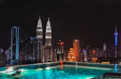 a swimming pool with a view of a city at night at Expressionz Suite KL City Center KLCC in Kuala Lumpur