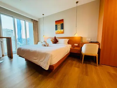 a bedroom with a bed with a desk and a chair at Bukit Ceylon Suites At RMAD KLCC in Kuala Lumpur