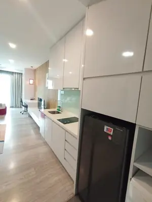 a kitchen with white cabinets and a black refrigerator at Bukit Ceylon Suites At RMAD KLCC in Kuala Lumpur