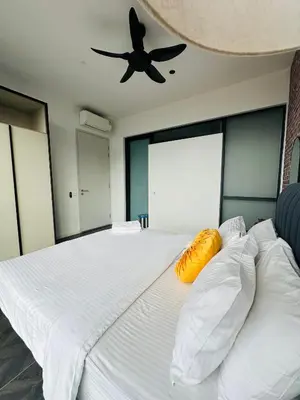 a bedroom with a large white bed with a ceiling fan at Scarletz Suites KLCC by Dream in Kuala Lumpur