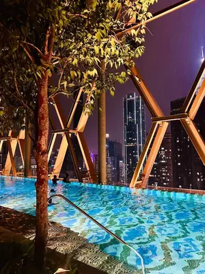 a swimming pool with a city skyline at night at Scarletz Suites KLCC by Dream in Kuala Lumpur
